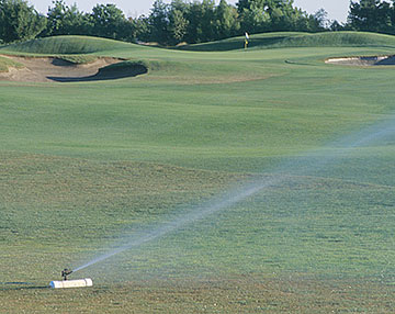 Photo: Moderately close shot of sprinklers in action at golf course